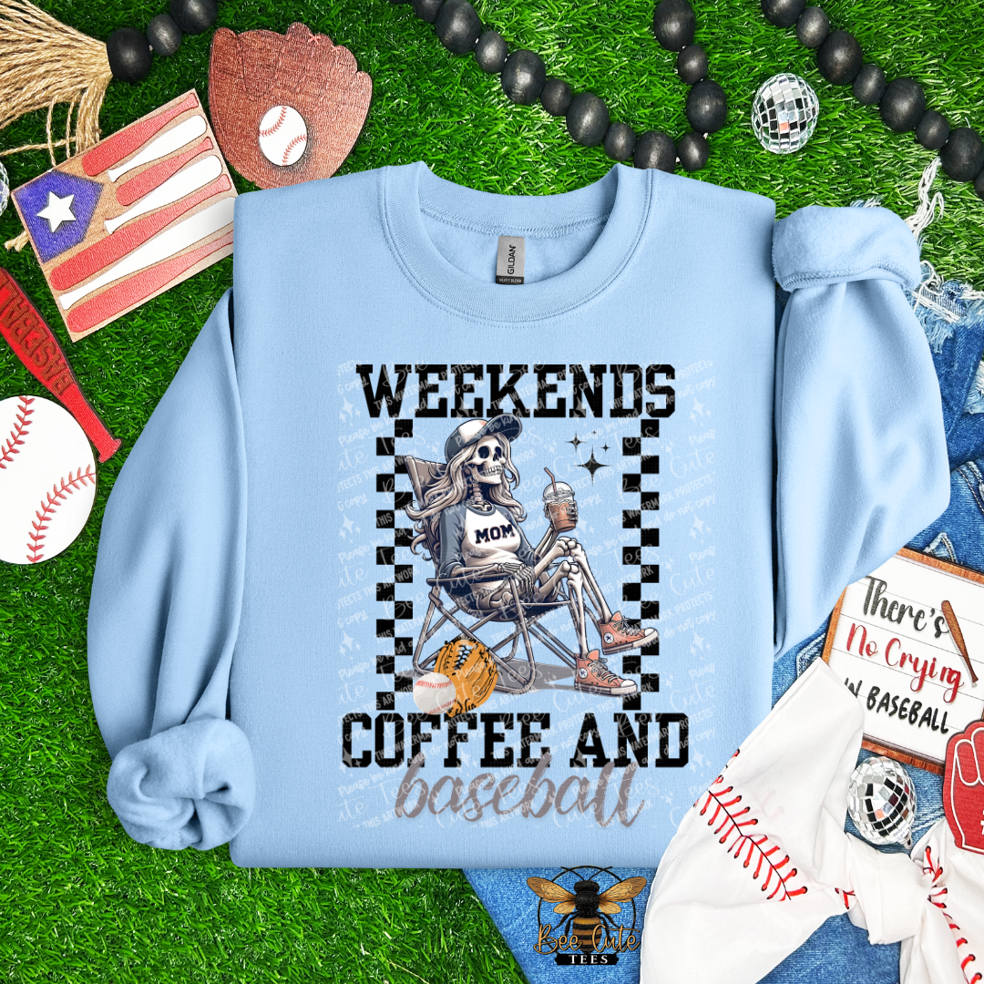 Light blue sweatshirt with skeleton graphic and text 'Weekends Coffee and Baseball' on a grass background with sports-themed items.