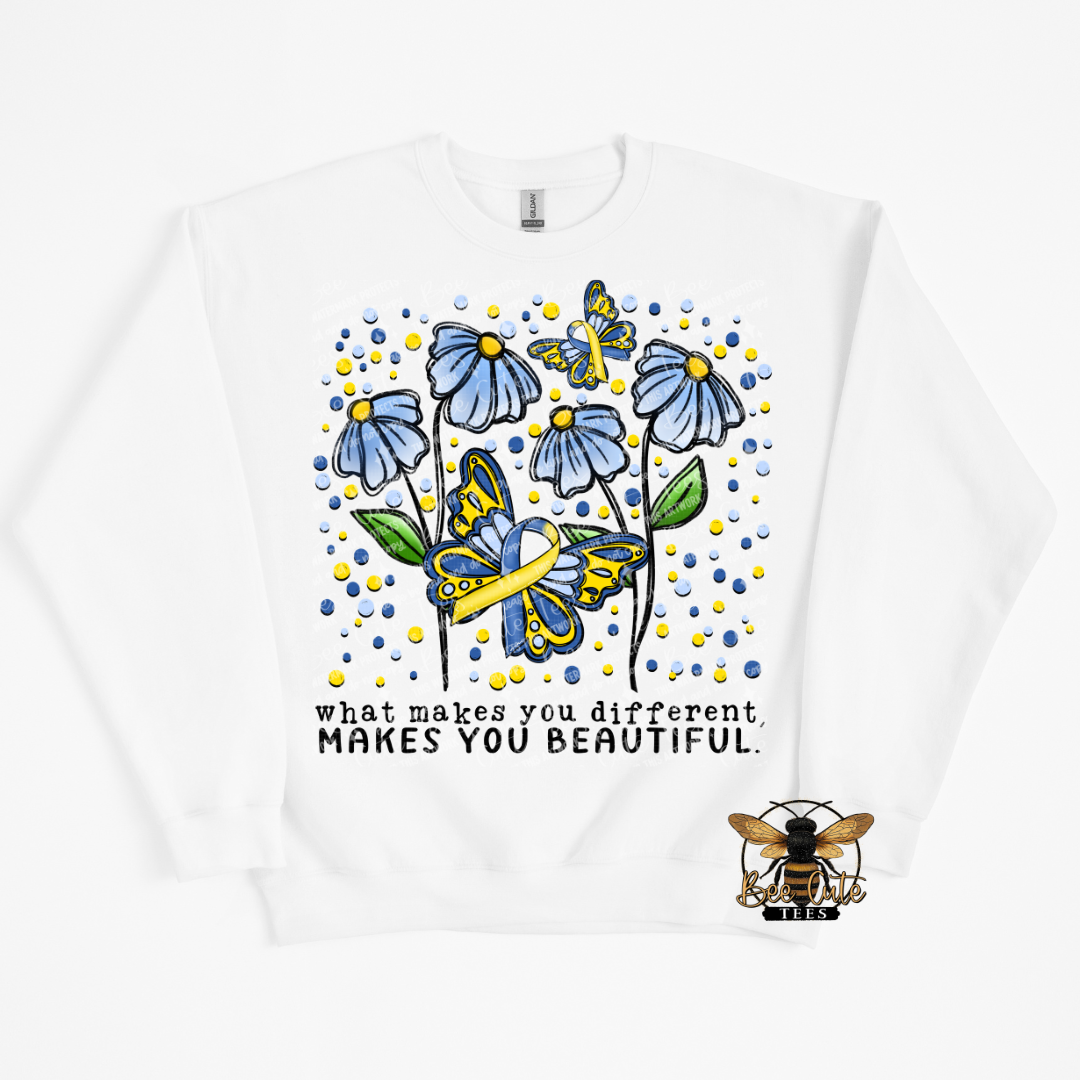 White sweatshirt with blue flowers, yellow ribbons, and text 'What makes you different, makes you beautiful' on a white background.