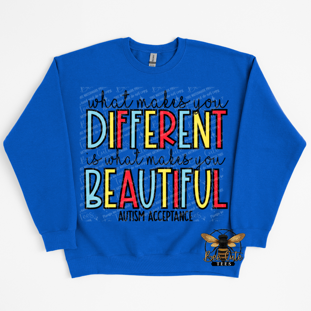 Blue sweatshirt with colorful text 'What makes you different is what makes you beautiful' on a white background