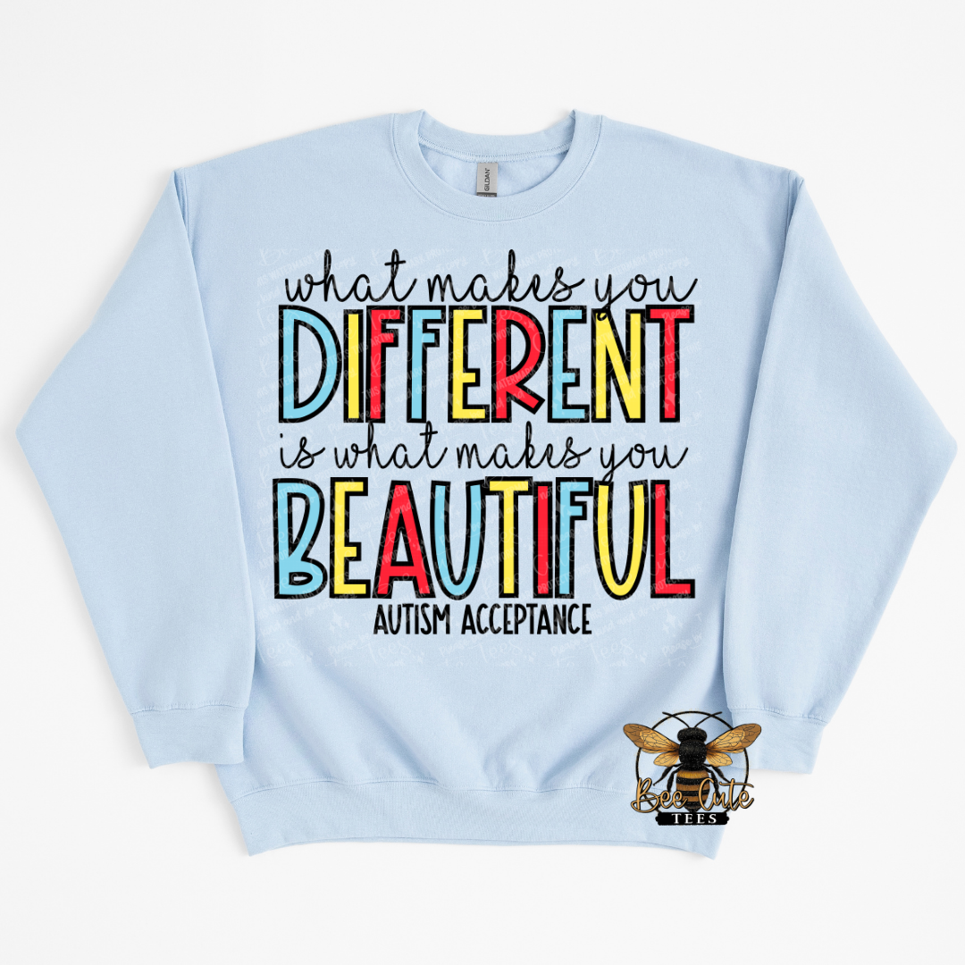 Light blue sweatshirt with colorful text 'What makes you different is what makes you beautiful' on a white background