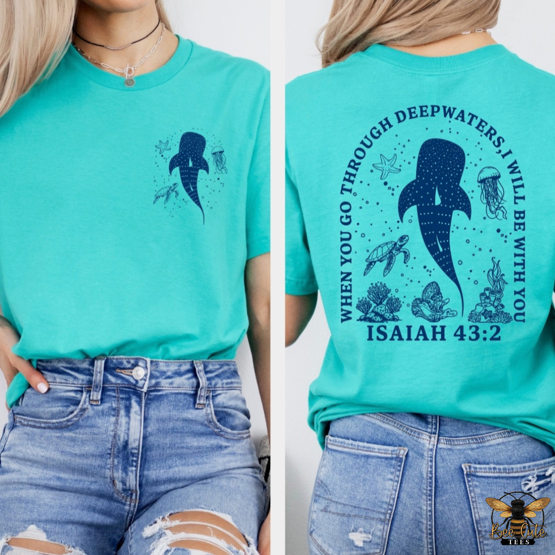 A split view of a woman wearing a turquoise short-sleeve graphic T-shirt, showing the front and back. The front has a small dark navy whale print on the left chest.