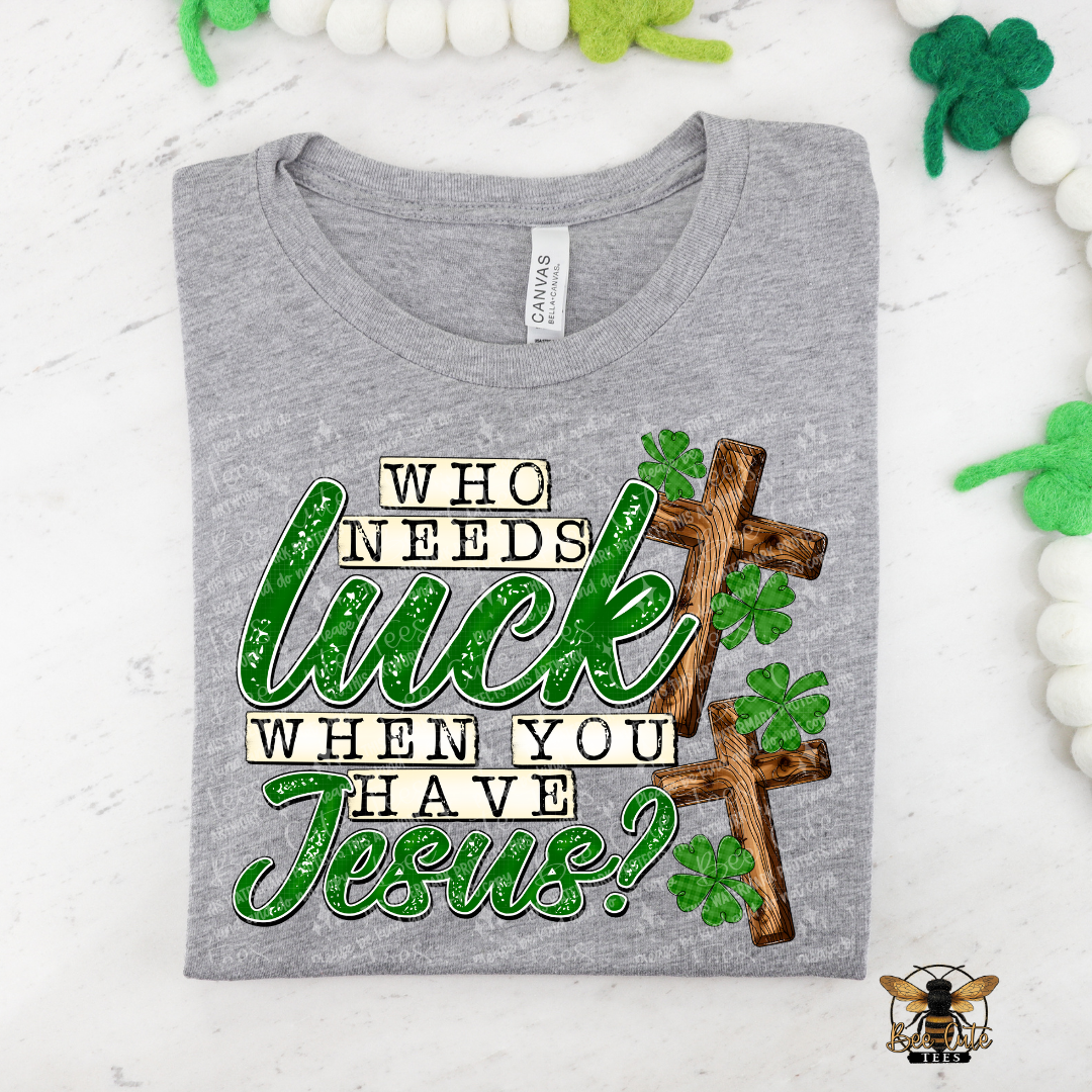 Gray t-shirt with a graphic design featuring text and a cross, on a white background with decorative elements.