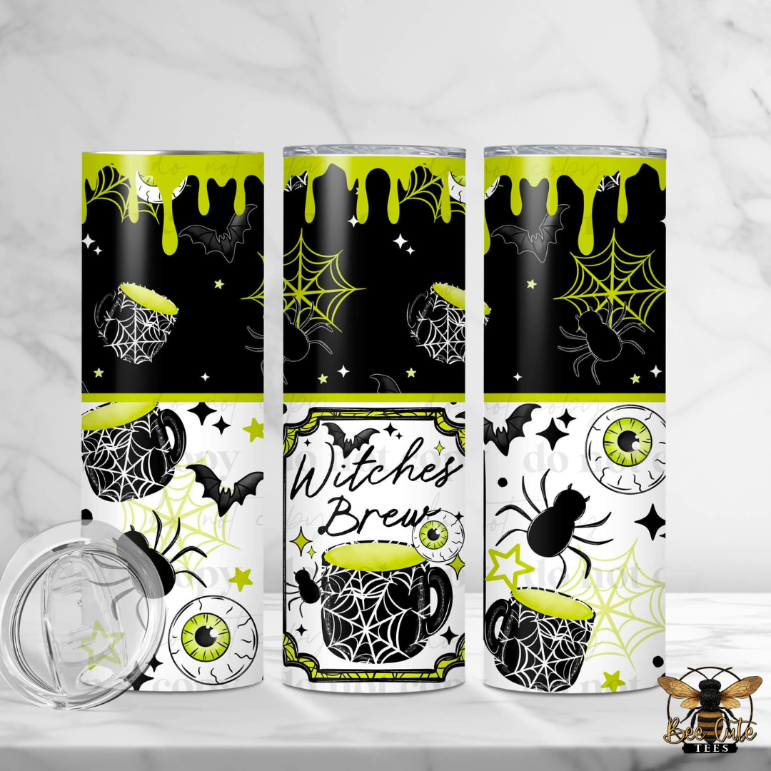 Three Halloween-themed insulated tumblers with a clear lid are displayed on a white marble surface. The tumblers feature a black and white graphic design with neon yellow-green accents, including spiderwebs, bats, eyeballs, and a mug with the text 'Witches Brew'.