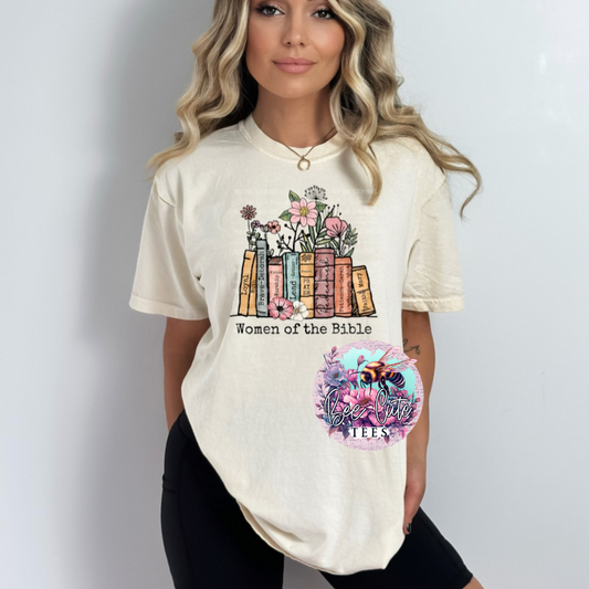 Cream graphic t-shirt featuring a “Women of the Bible” design with stacked books and floral accents, styled on a model in a simple, neutral setting.
