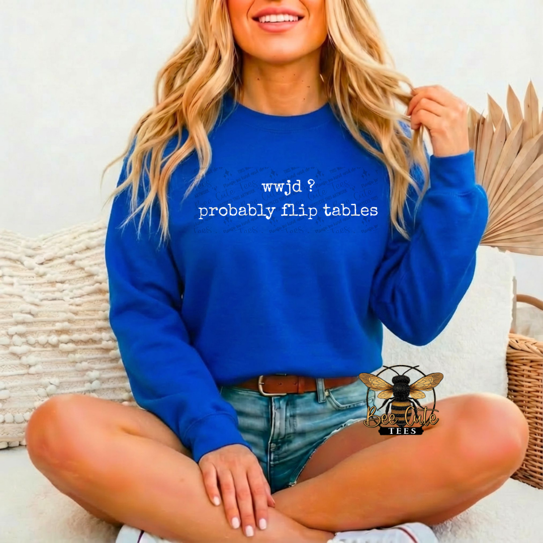 Person wearing a blue sweatshirt with text, sitting on a white surface.