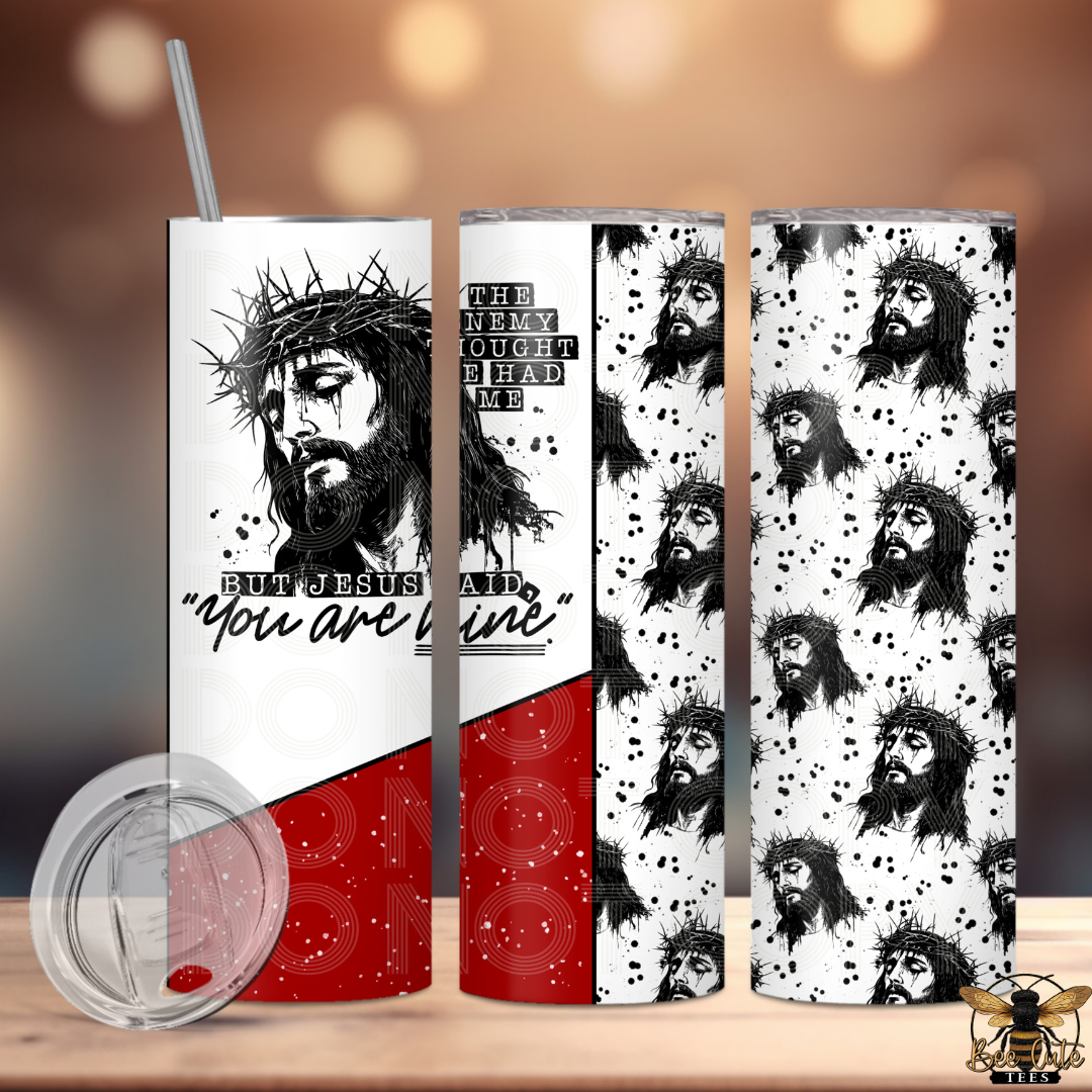 Three tumblers with Jesus-themed designs on a wooden surface.