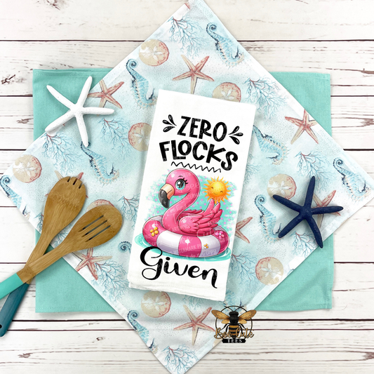 Flamingo-themed card with 'Zero Flocks Given' text on a decorative cloth with starfish and seashell pattern.